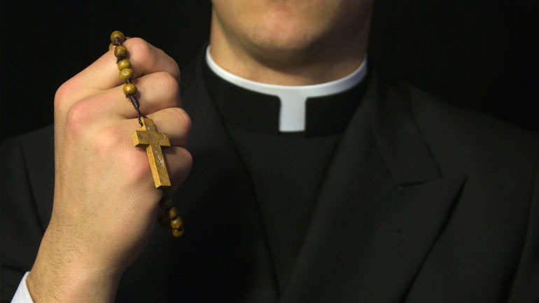 Priest holding rosary beads