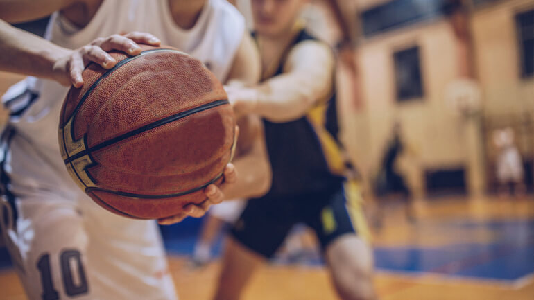 Basketball player guards from steal