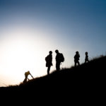 silhouettes of boy scout leader and boy scouts.